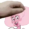 a cartoon character with pink hair is being propped up by a person 's hand .