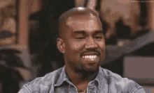 a man in a denim shirt is smiling with a caption that says ' il fct ' on it .