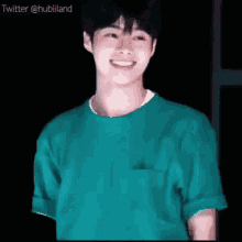 a young man in a green t-shirt is smiling .
