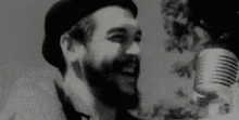 a man with a beard is singing into a microphone .