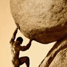 a muscular man is pushing a large rock up a hill .