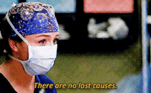 a woman wearing a surgical mask and a hat says there are no lost causes