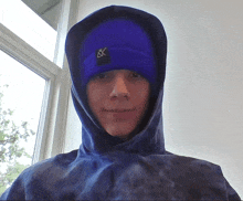 a man wearing a blue beanie and a blue hoodie