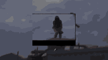 a man without a shirt is standing on top of a building in a video .