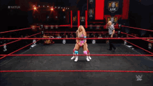 two women wrestle in a ring with the letters nxtuk on the bottom right