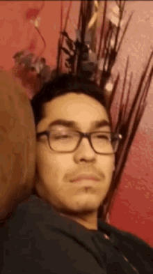 a young man wearing glasses is laying on a couch with his eyes closed