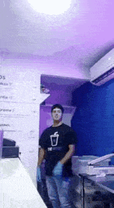 a man wearing gloves is standing in a kitchen .