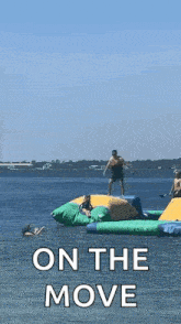 a group of people are playing on an inflatable water park .