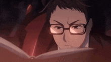 a man with glasses is reading a book