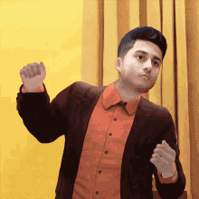 a man in a suit and orange shirt is dancing