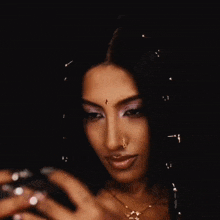 a woman with a nose ring is taking a selfie with her phone