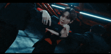 a group of men are dancing in a dark room and one of them is wearing a red shirt with the letter c on it