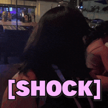 a woman standing in front of a sign that says shock