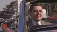 a man in a suit and tie is sitting in a car