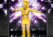 a woman in a yellow costume is standing in front of a screen that says tumblr on it