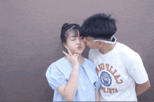 a boy kisses a girl on the cheek while wearing a shirt that says dallas