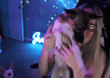 a woman is holding a dog in front of a sign that says ' ju '