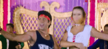 a man and a woman are dancing in front of a colorful background with the word music on the bottom right