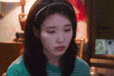 a woman wearing a green and white striped shirt and a headband