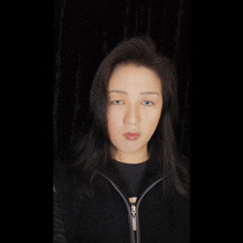 a woman wearing a black jacket with a zipper that says ' eoo ' on it