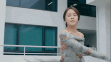 a woman is dancing in front of a building