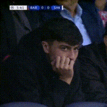 a blurry picture of a man sitting in a stadium watching a game between bar and shk