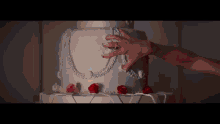 a woman 's hand is reaching for a white cake
