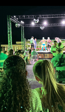 people watching a wrestling match with a sign that says lucha libre on it
