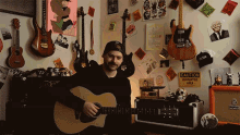 a man playing an acoustic guitar in front of a caution sign