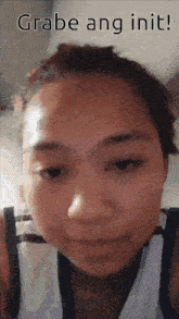 a close up of a woman 's face with the words grabe ang init below her