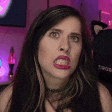 a close up of a woman making a funny face with her mouth open and her teeth showing .