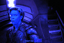 a man with blue paint on his face is reaching out his hand with the words " don 't be blue " written below him
