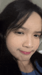 a close up of a woman 's face with a slight smile
