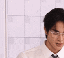 a man wearing glasses and a white shirt has a colorful ball on his head