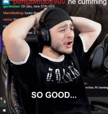 a man wearing headphones is sitting in a chair with his hands behind his head .