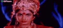 a close up of a woman wearing a red dress and a crown .