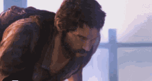 a man with a beard is standing in front of a window looking down