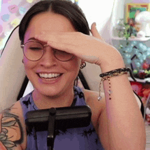 a woman wearing glasses is smiling and covering her eyes