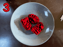 a plate with three red hearts on it and the number 3 behind it