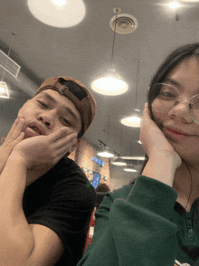 a man and a woman are posing for a picture and the woman is wearing glasses