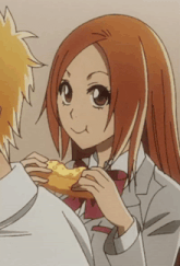 a girl with red hair is eating a piece of pizza