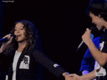 a man holding a woman 's hand while she sings