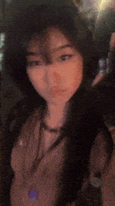 a close up of a woman 's face with a purple necklace