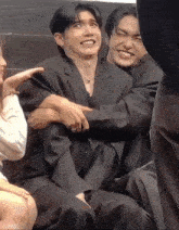 a man in a suit is being hugged by another man in a suit