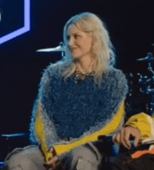 a woman in a blue and yellow sweater is sitting next to a man in a yellow jacket .