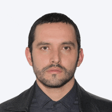 a man with a beard is wearing a black jacket and a plaid shirt