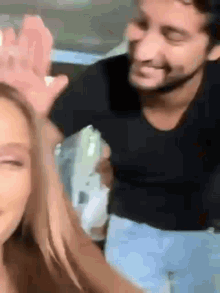 a man and a woman are standing next to each other .