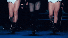 a woman in a black dress is surrounded by three other women in white underwear