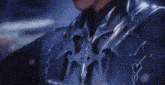 a close up of a person wearing a blue jacket with a necklace around their neck