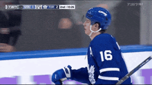 a hockey player wearing a blue jersey with the number 16 on it